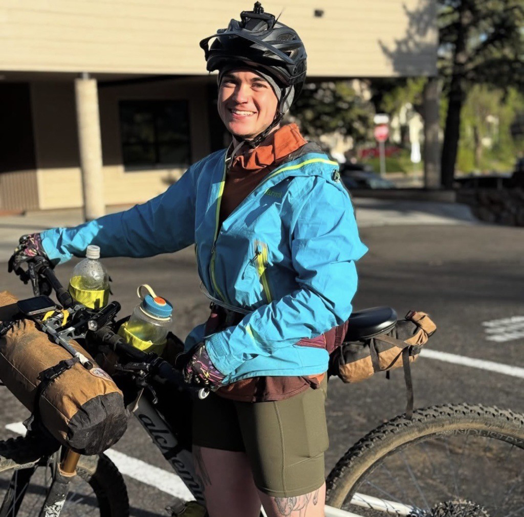 Mountain biker standing with their bike